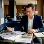 Small business owner reviewing financial reports in office