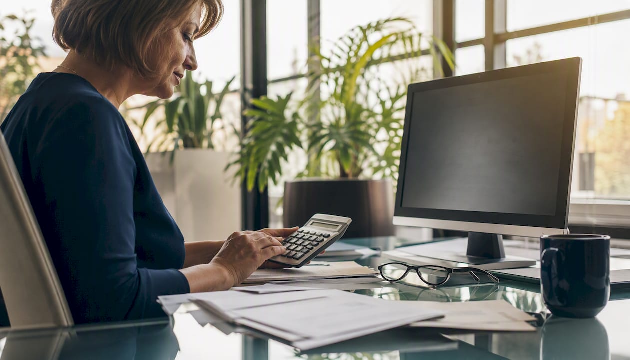 Close-up of hands manually calculating payroll in healthcare office