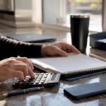 Hands calculating and arranging bookkeeping documents