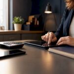 Hands entering bookkeeping data on tablet