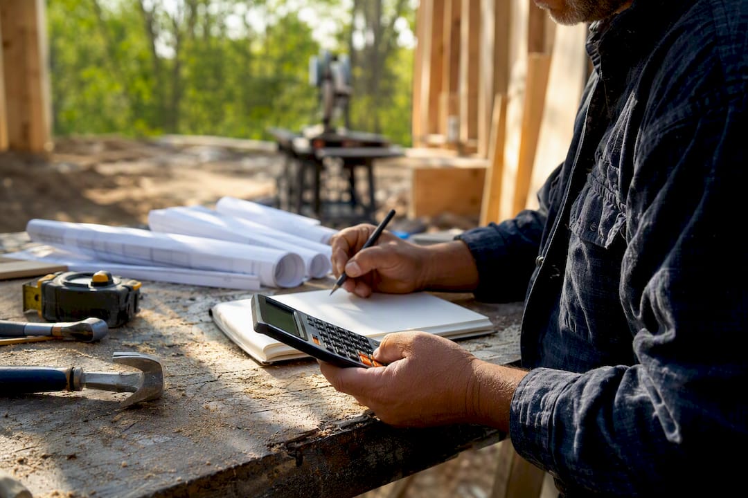 Contractor calculating job costs at desk