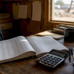 Ledger and calculator on contractor's desk